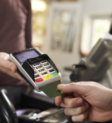 customer makes credit card payment over counter at gun shop